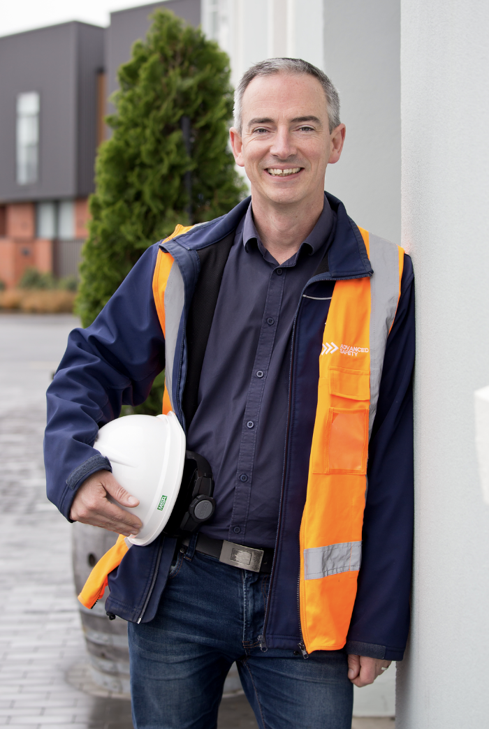 Matt Jones in Advanced Safety high visibility gear holding a hard hat